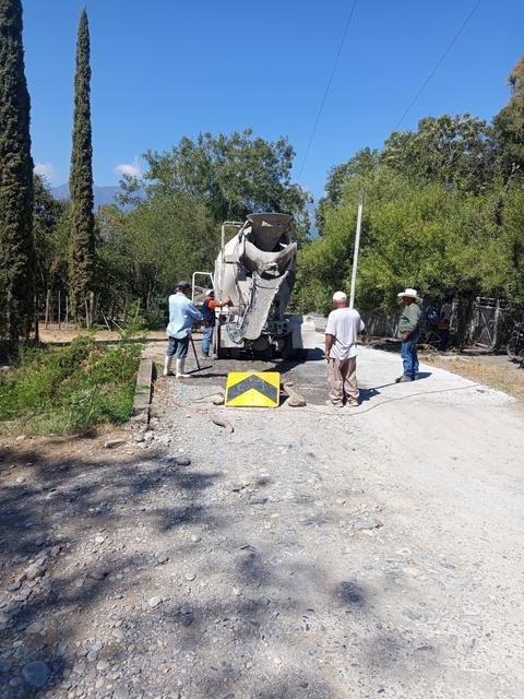 Vecinos junto a un camión de concreto durante los trabajos en El Fresno.