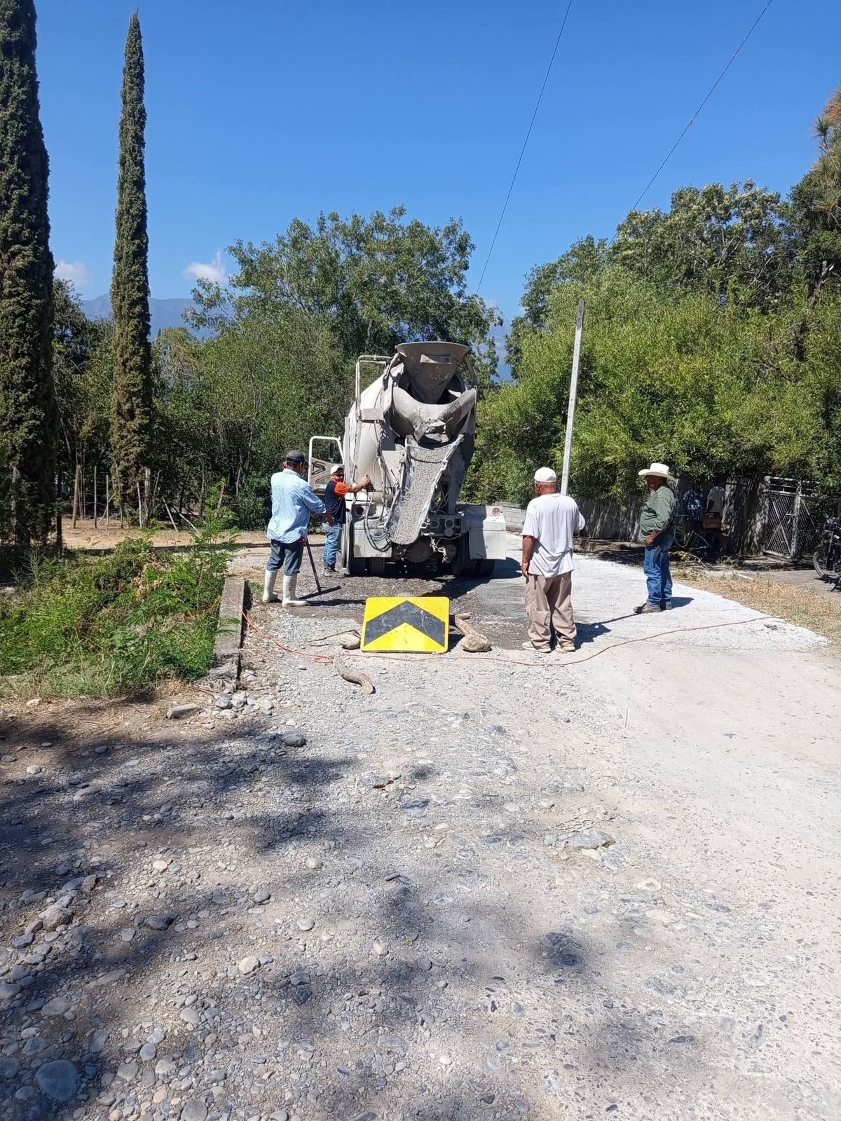 Vecinos junto a un camión de concreto durante los trabajos en El Fresno.