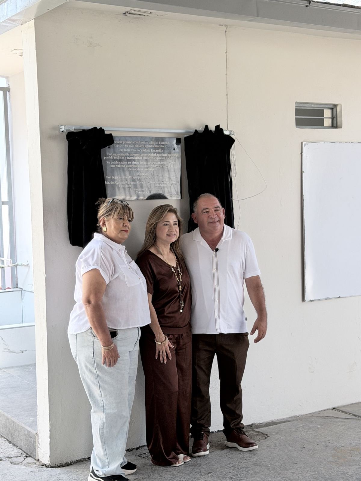 Participantes del evento junto a la placa de reconocimiento en la primaria Sebastián Villegas Cumplido.